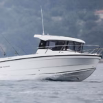 Parker 700 Piltothouse speeding along flat waters with sea spraying off the back