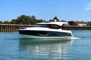 Parker Monaco 110 luxury sport cruiser underway on calm blue water, showcasing its sleek hull and panoramic cabin windows.