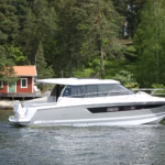 motor cruiser underway, showing the starboard profile, spacious wheelhouse and contemporary hull design